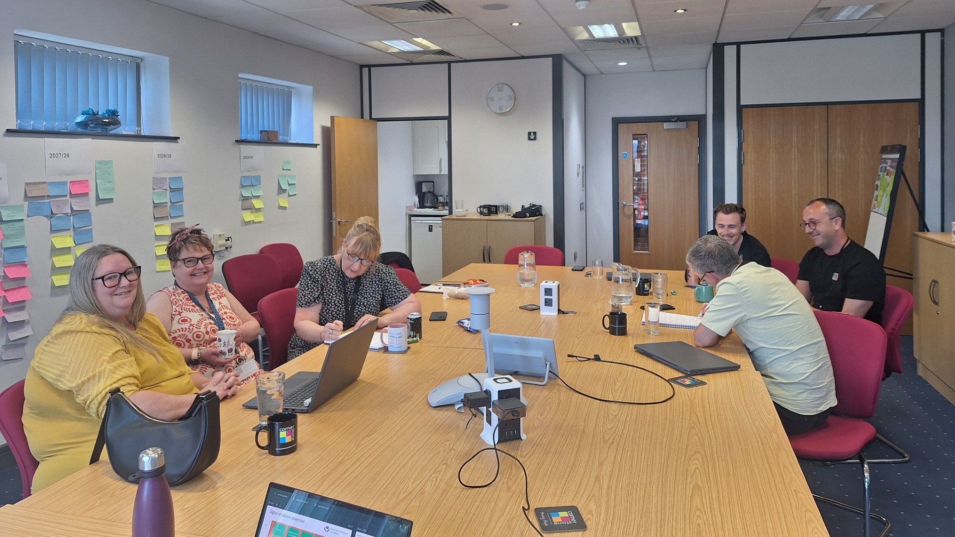Housing team gathered around a boardroom table during a Cornerstone training session